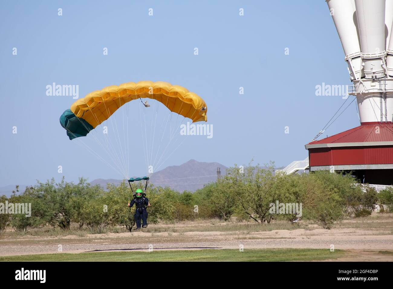 Le parachutiste débarque son parachute avec le simulateur de chute libre en arrière-plan. Banque D'Images