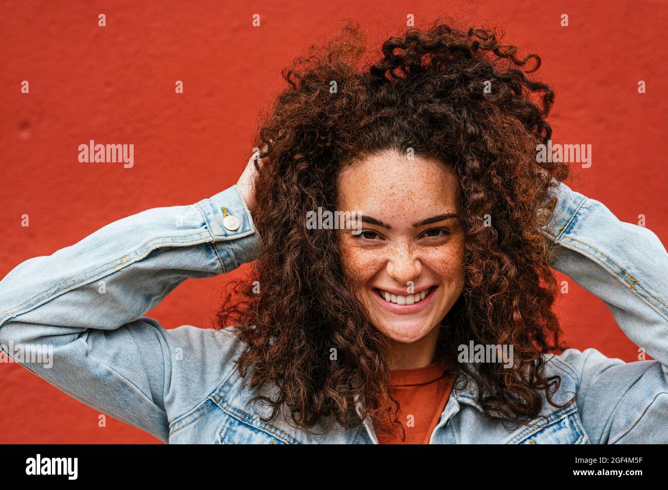 Belle jeune femme heureuse avec les mains dans les cheveux Banque D'Images