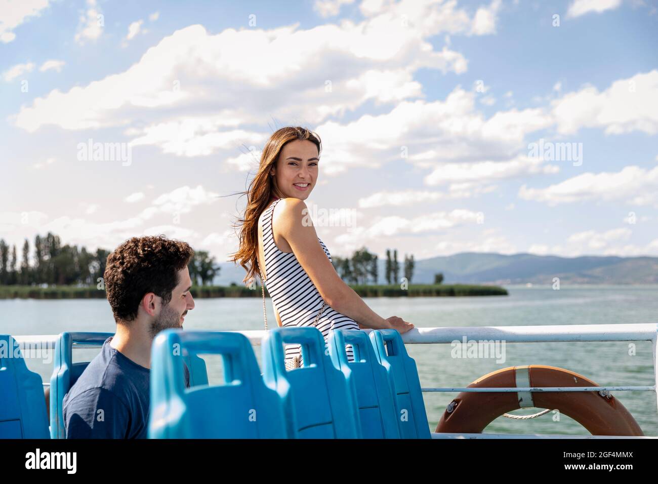Femme souriant debout près des balustrades de voitures de tourisme Banque D'Images