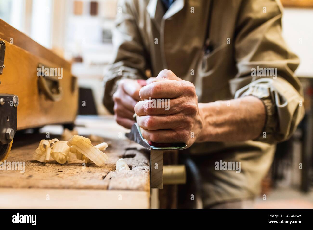 Artisan mâle mature sciant du bois à l'atelier Banque D'Images