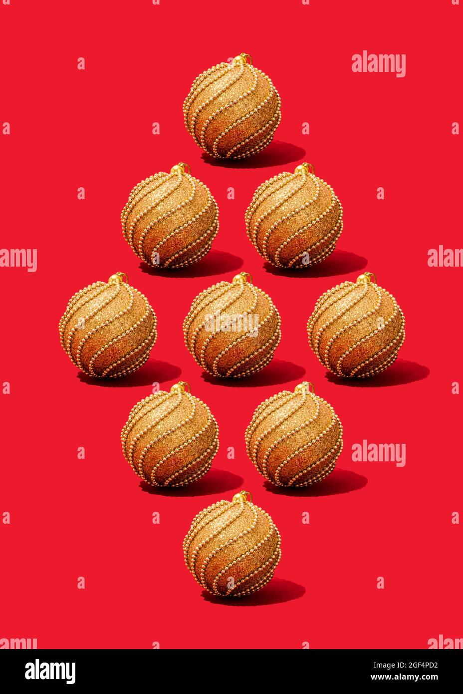 Studio photo de décorations de Noël dorées plates sur fond rouge vif Banque D'Images