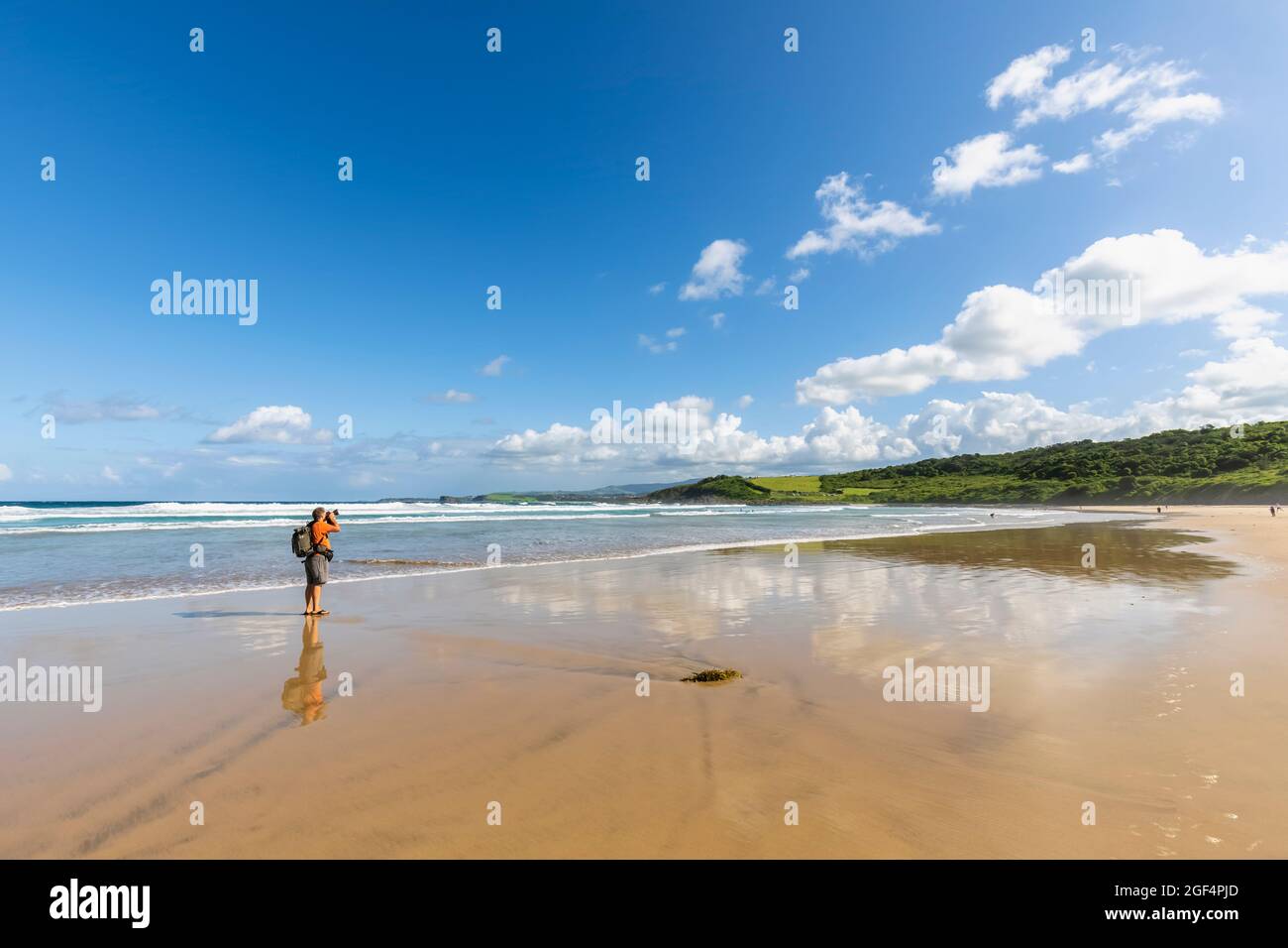 Un randonneur prend des photos à Killalea Beach Banque D'Images