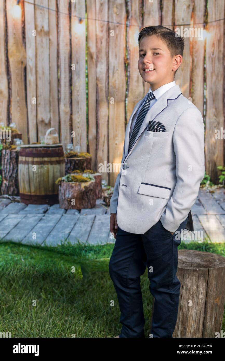 Gros plan vertical d'un jeune garçon dans un blazer gris clair et un  pantalon bleu Photo Stock - Alamy