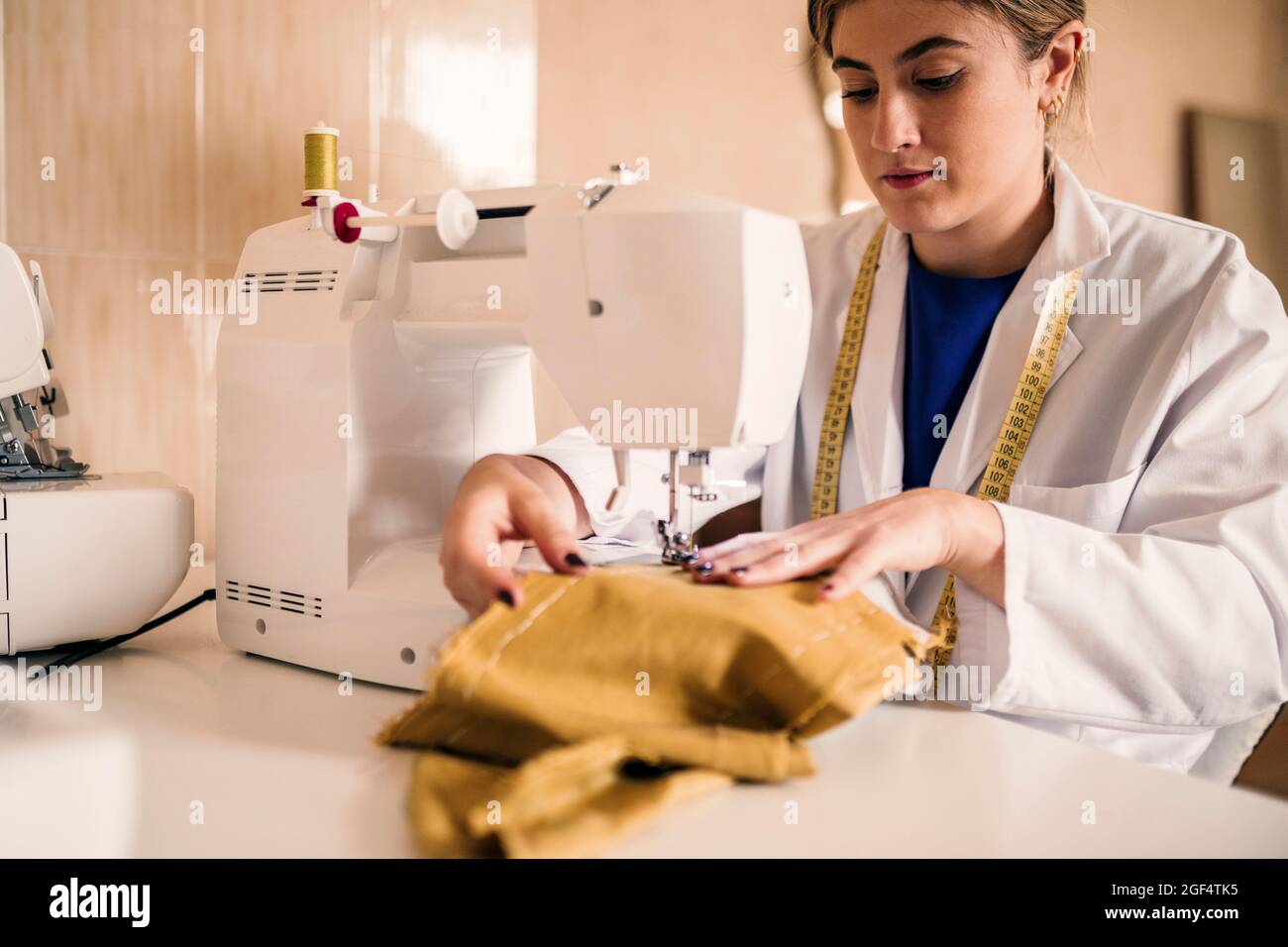Jeune couturière couturière couture de tissu à travers la machine à l'atelier Banque D'Images
