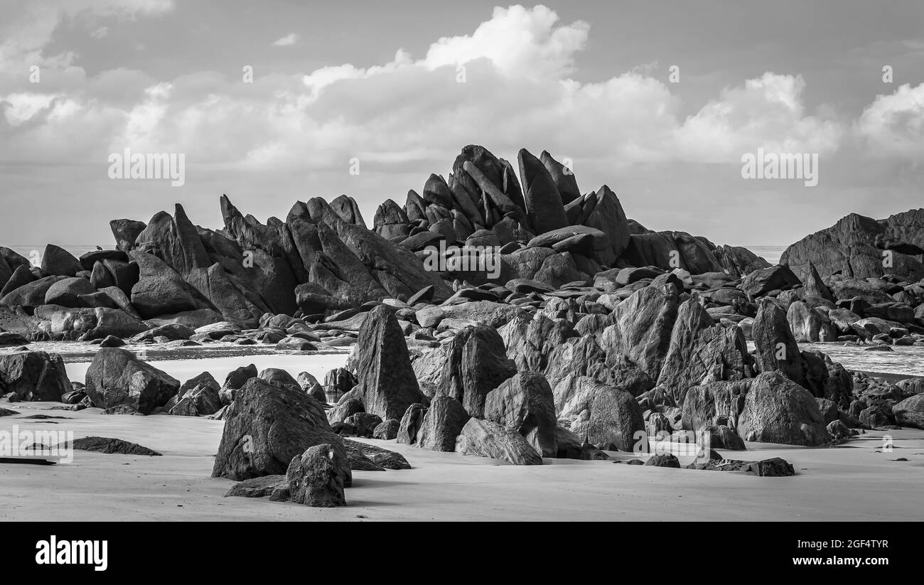 Blocs noirs sombres se trouvant sur une plage après la côte dans Axim Ghana Afrique de l'Ouest Banque D'Images