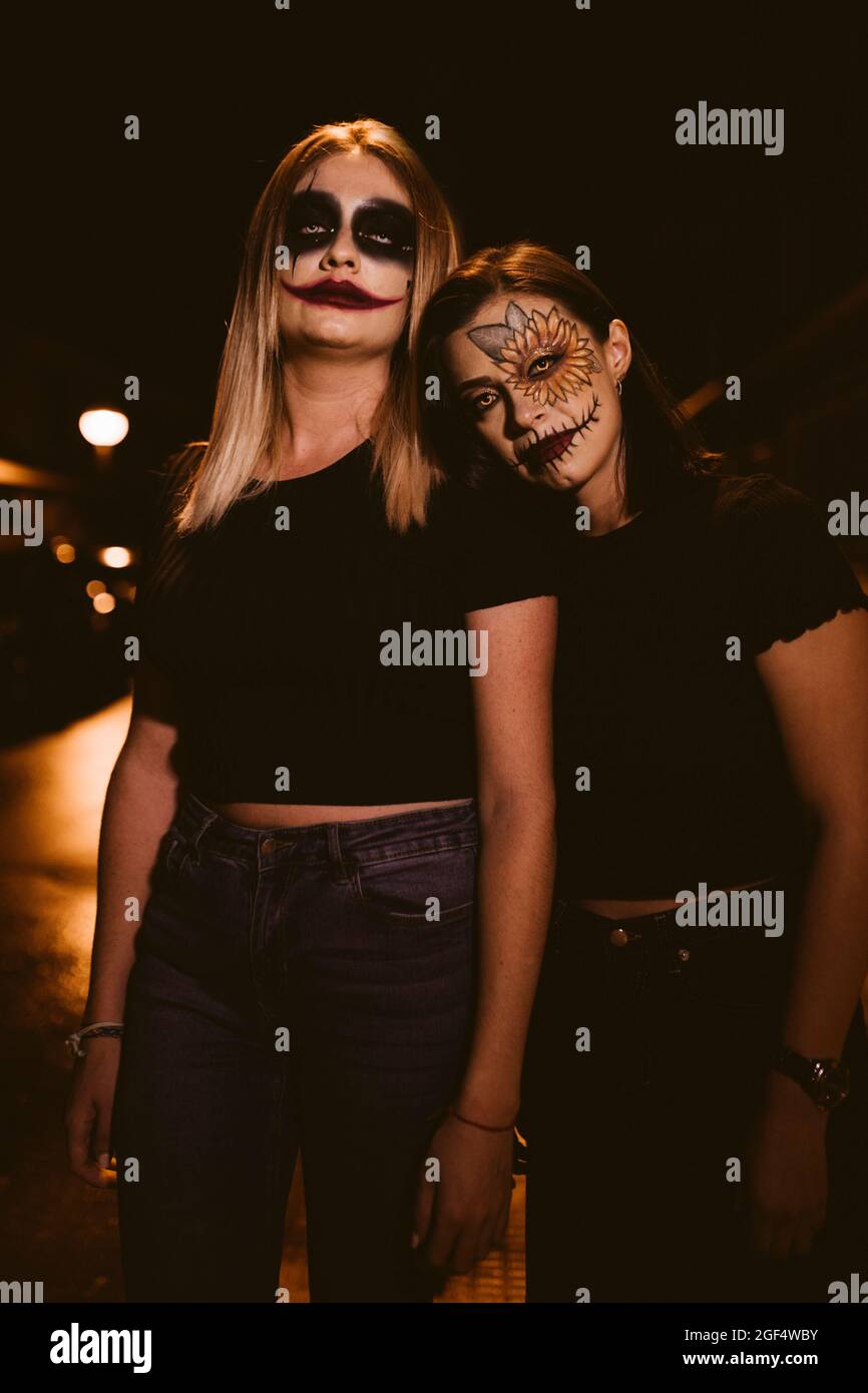 Femmes avec maquillage cérémonial debout sur la route pendant Halloween Banque D'Images