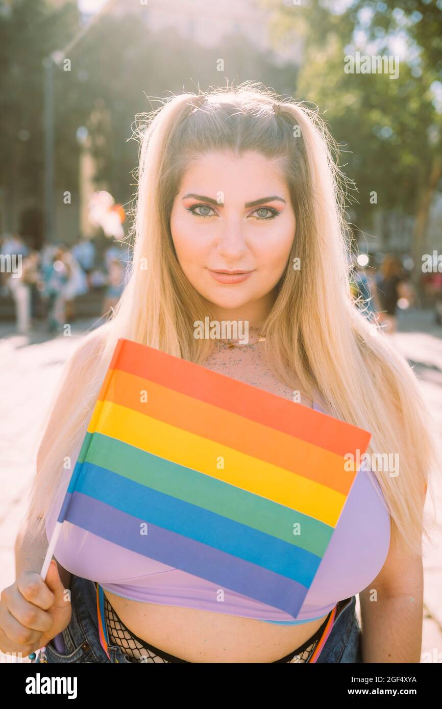 Jeune femme avec drapeau arc-en-ciel pendant la journée ensoleillée Banque D'Images