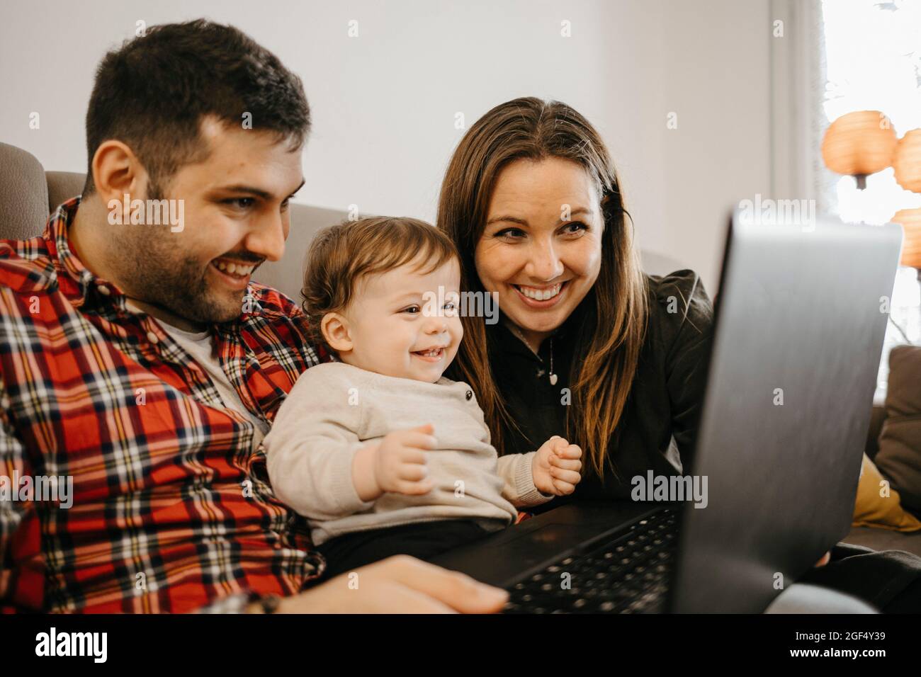 Famille heureuse pendant les appels vidéo sur ordinateur portable à la maison Banque D'Images