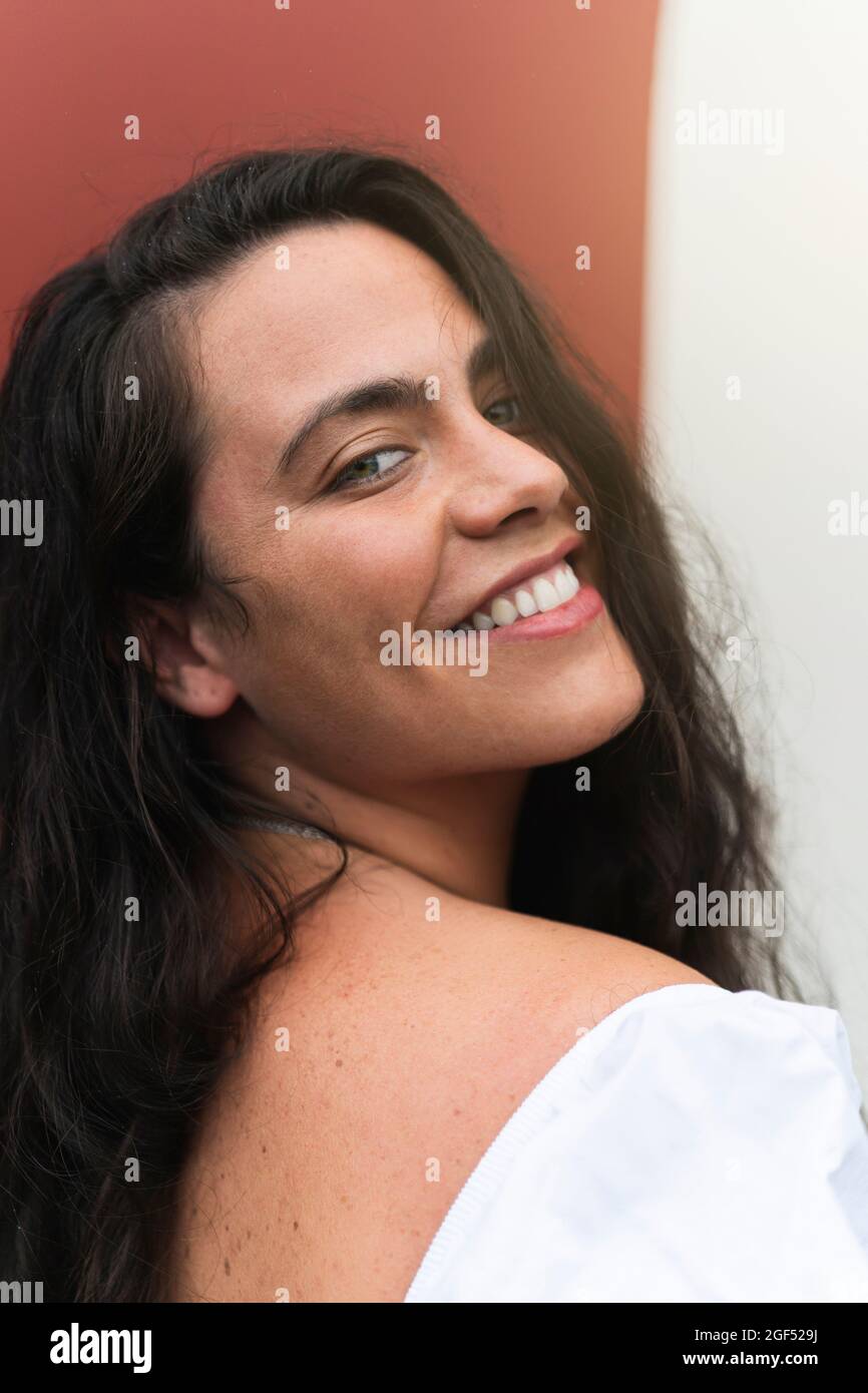 Jeune femme souriante avec de longs cheveux noirs Banque D'Images