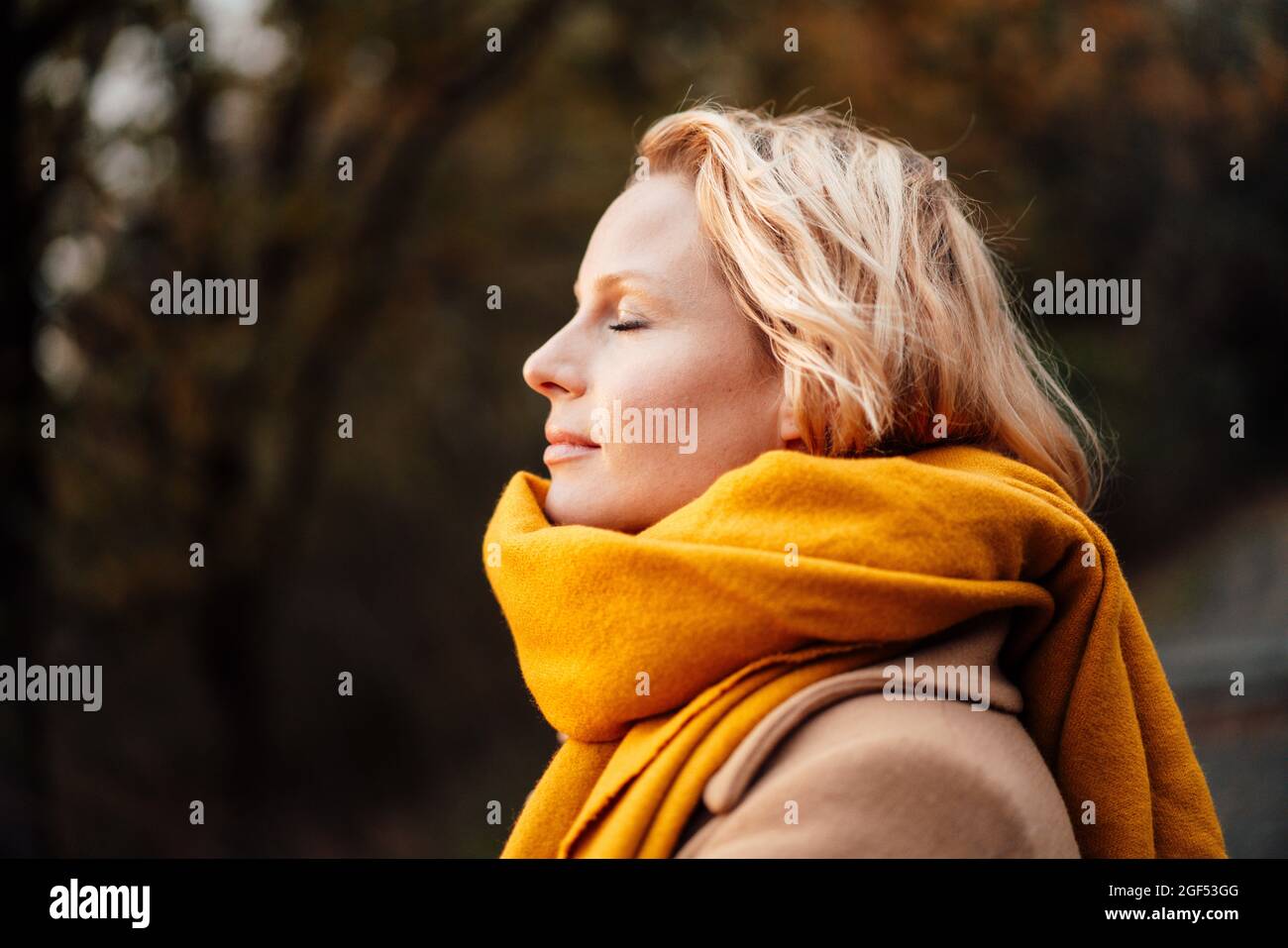 Femme blonde avec les yeux fermés portant un châle Banque D'Images