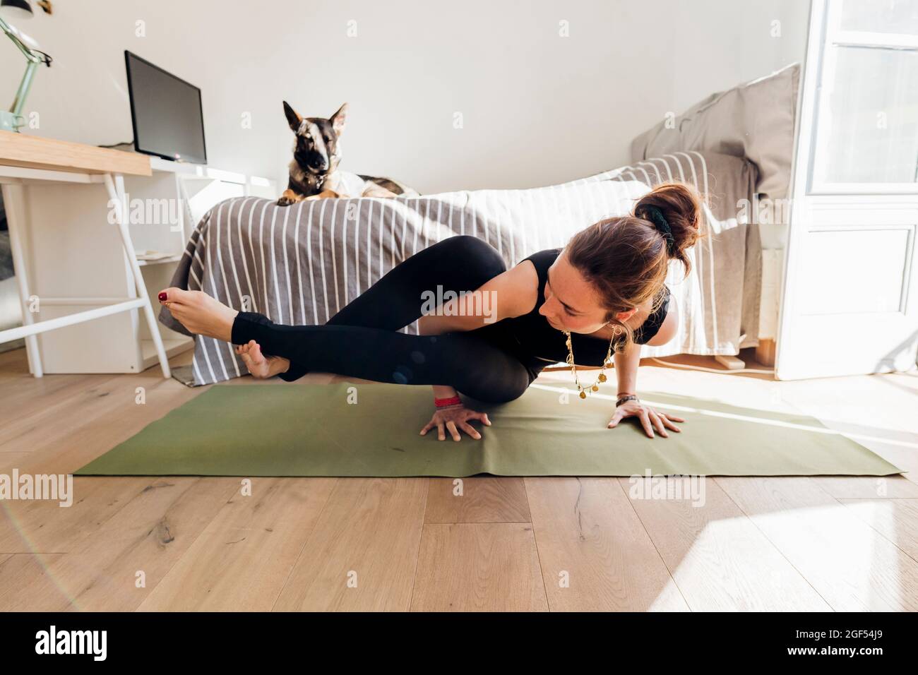 Femme pratiquant le yoga sur un tapis d'exercice dans la chambre à l'appartement Banque D'Images