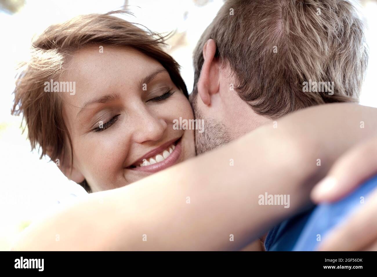 Belle femme souriante embrassant petit ami Banque D'Images