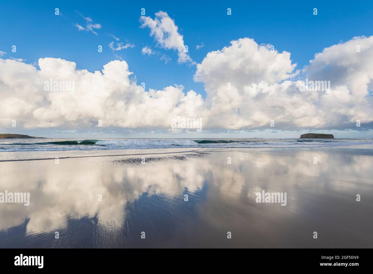 Nuages se reflétant dans l'eau côtière à Minnamurra Beach avec Stack Island en arrière-plan Banque D'Images