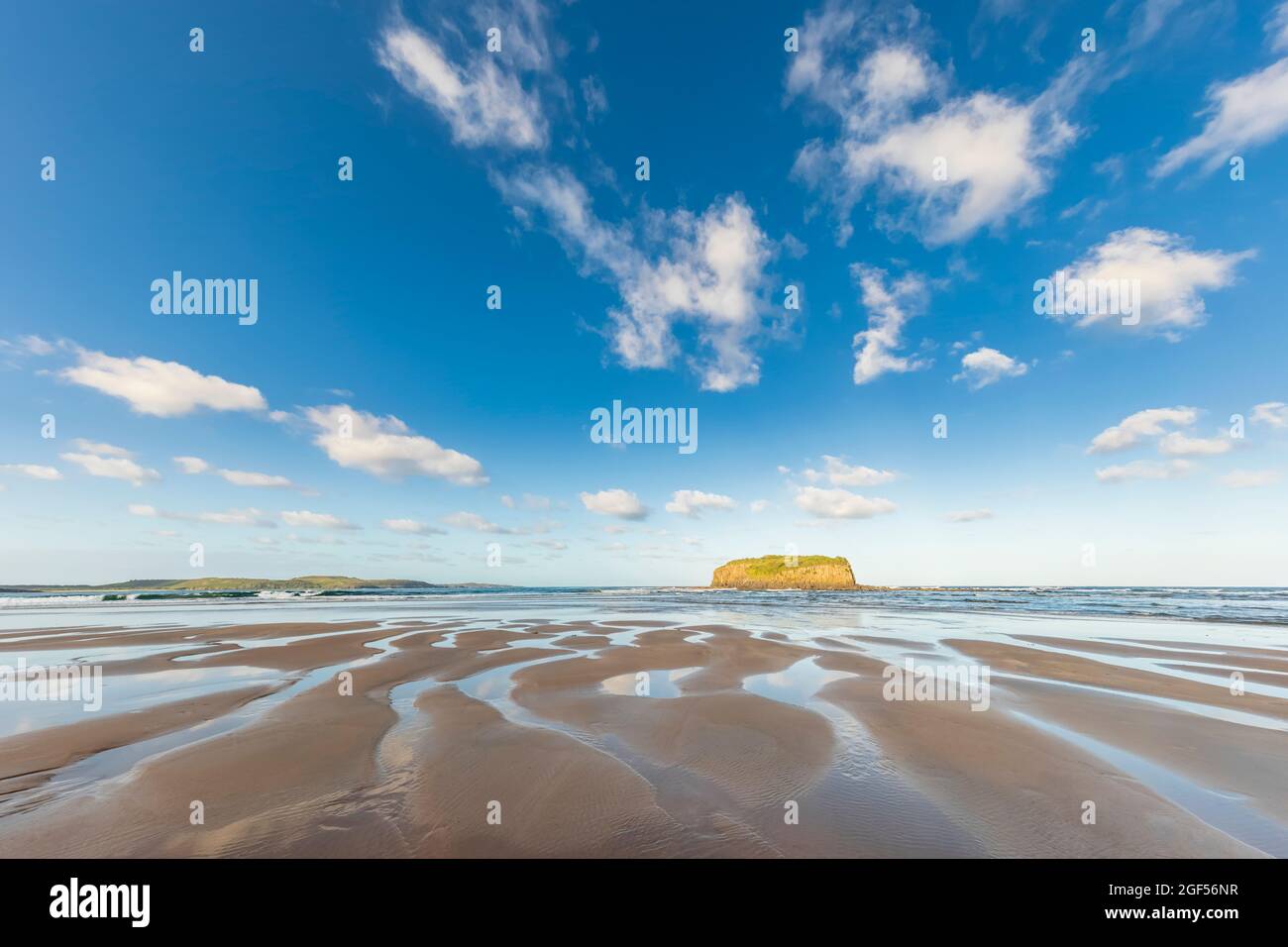 Ciel d'été au-dessus de la plage de Minnamurra avec Stack Island en arrière-plan Banque D'Images