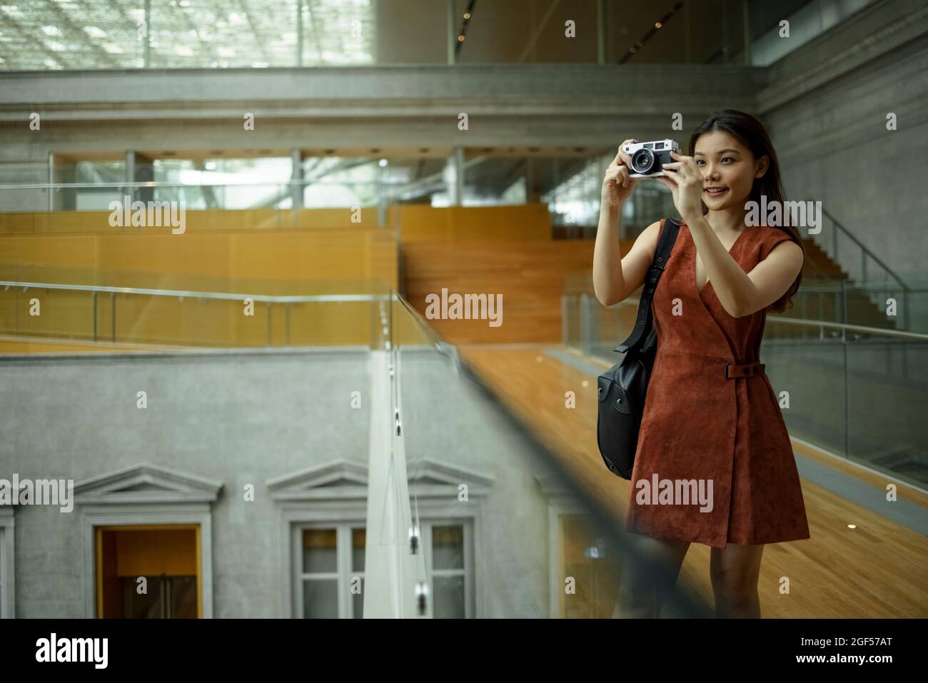 Une femme souriante qui photographie à travers l'appareil photo Banque D'Images
