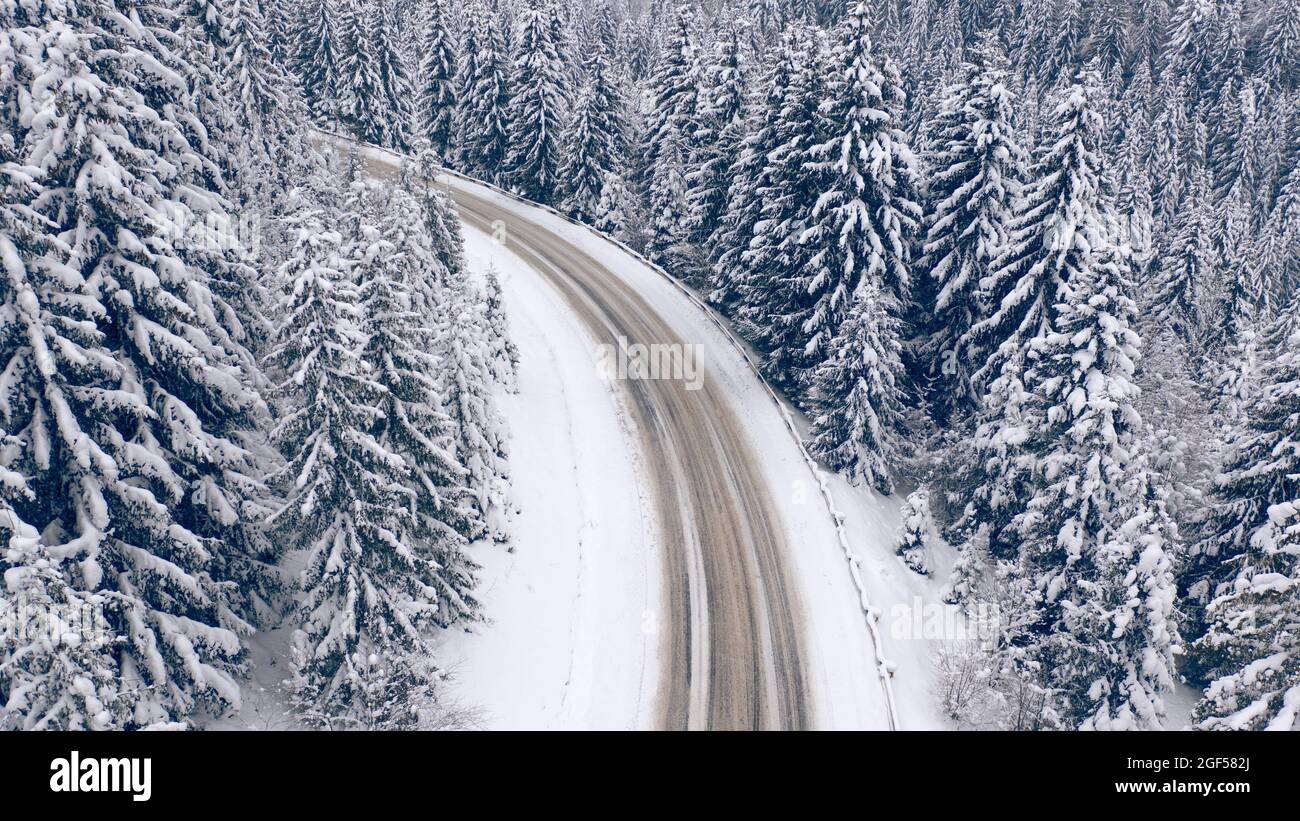 Magnifique paysage de montagne d'hiver. Route dans la forêt enneigée d'hiver. Vue de drone. Banque D'Images