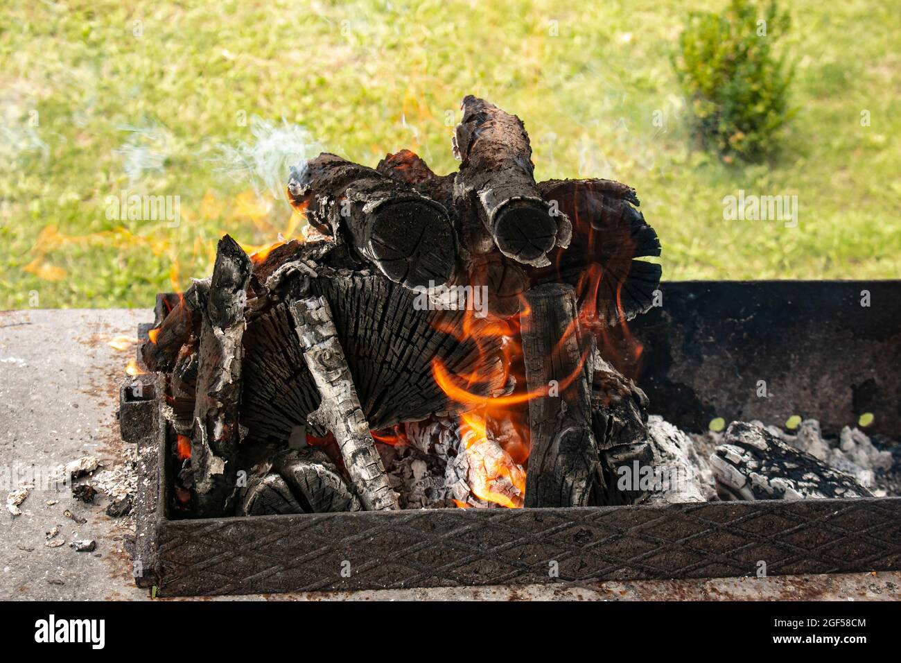 Charbons de feu de camp, bois de chauffage brûlant sur le grill. Texture feu de bois. Feu couvant. Les embres chauds du feu de bois en feu. Banque D'Images