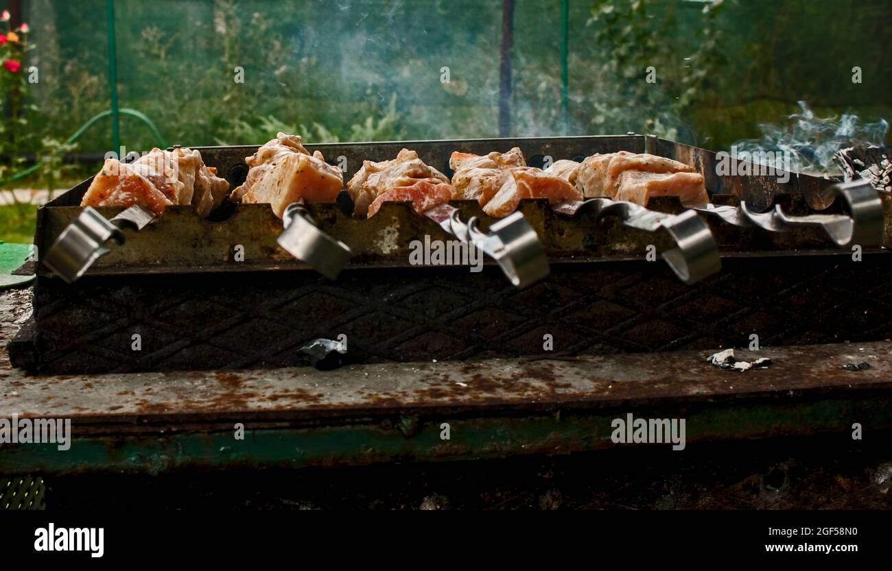 Shish kebab sur les brochettes à l'extérieur en gros plan. Brazier électrique avec brochettes tournantes. Banque D'Images