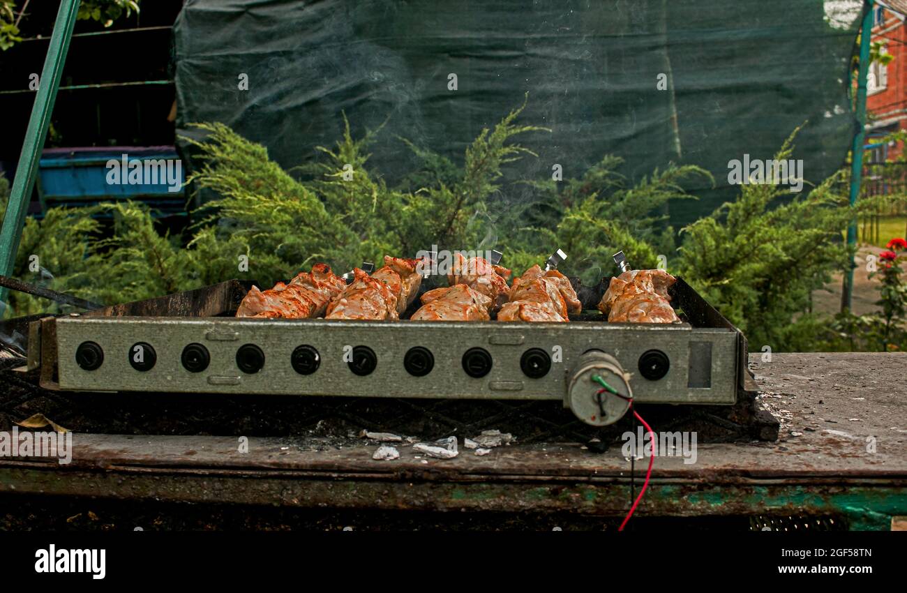 Shish kebab sur les brochettes à l'extérieur en gros plan. Brazier électrique avec brochettes tournantes. Banque D'Images