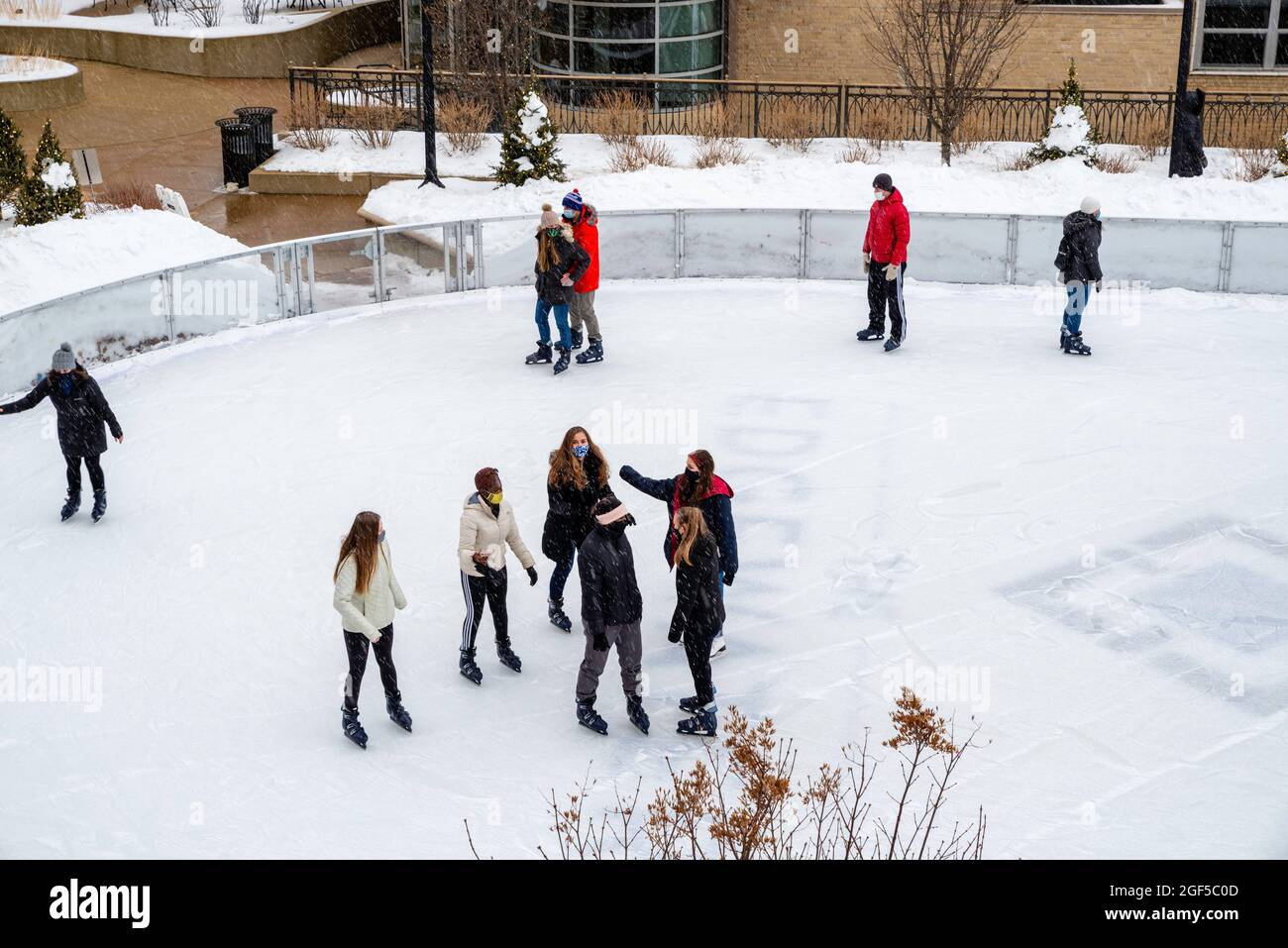 Les clients apprécient les sports d'hiver en patinant sur la patinoire de l'hôtel Edgewater ; Madison, Wisconsin, États-Unis. Février 2021. Banque D'Images