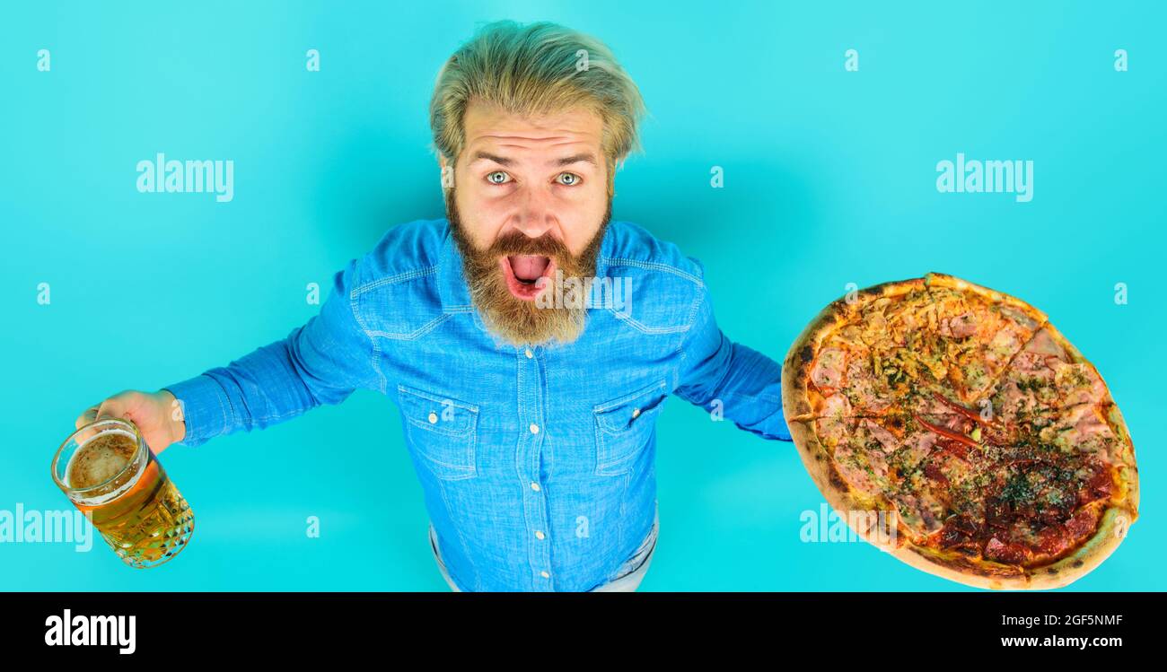 Homme barbu avec une savoureuse pizza et un verre de bière au restaurant. Délicieux repas rapide. Cuisine italienne. Déjeuner ou dîner. Banque D'Images