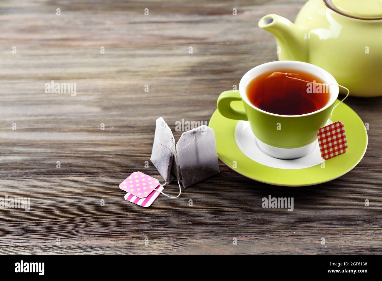 Tasse de thé avec des sachets de thé et théière sur fond de table en bois  Photo Stock - Alamy