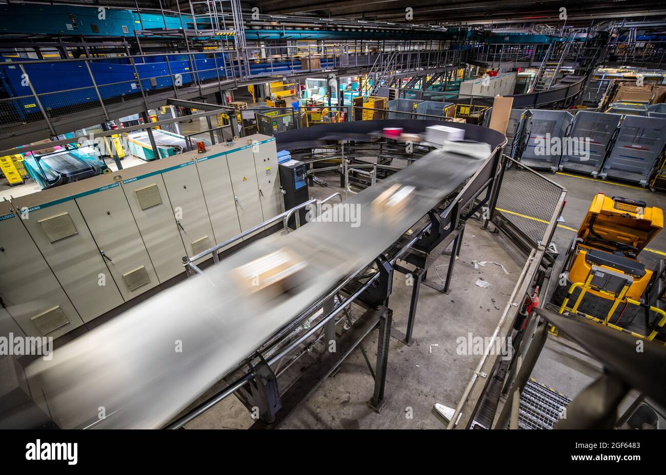 19 août 2021, Bade-Wurtemberg, Köngen : les colis sont transportés par le hall du centre de colis DHL à Köngen avec l'aide de courroies transporteuses. (À dpa: 'Grand volume de colis au centre de distribution DHL - Corona or Not') photo: Christoph Schmidt/dpa Banque D'Images