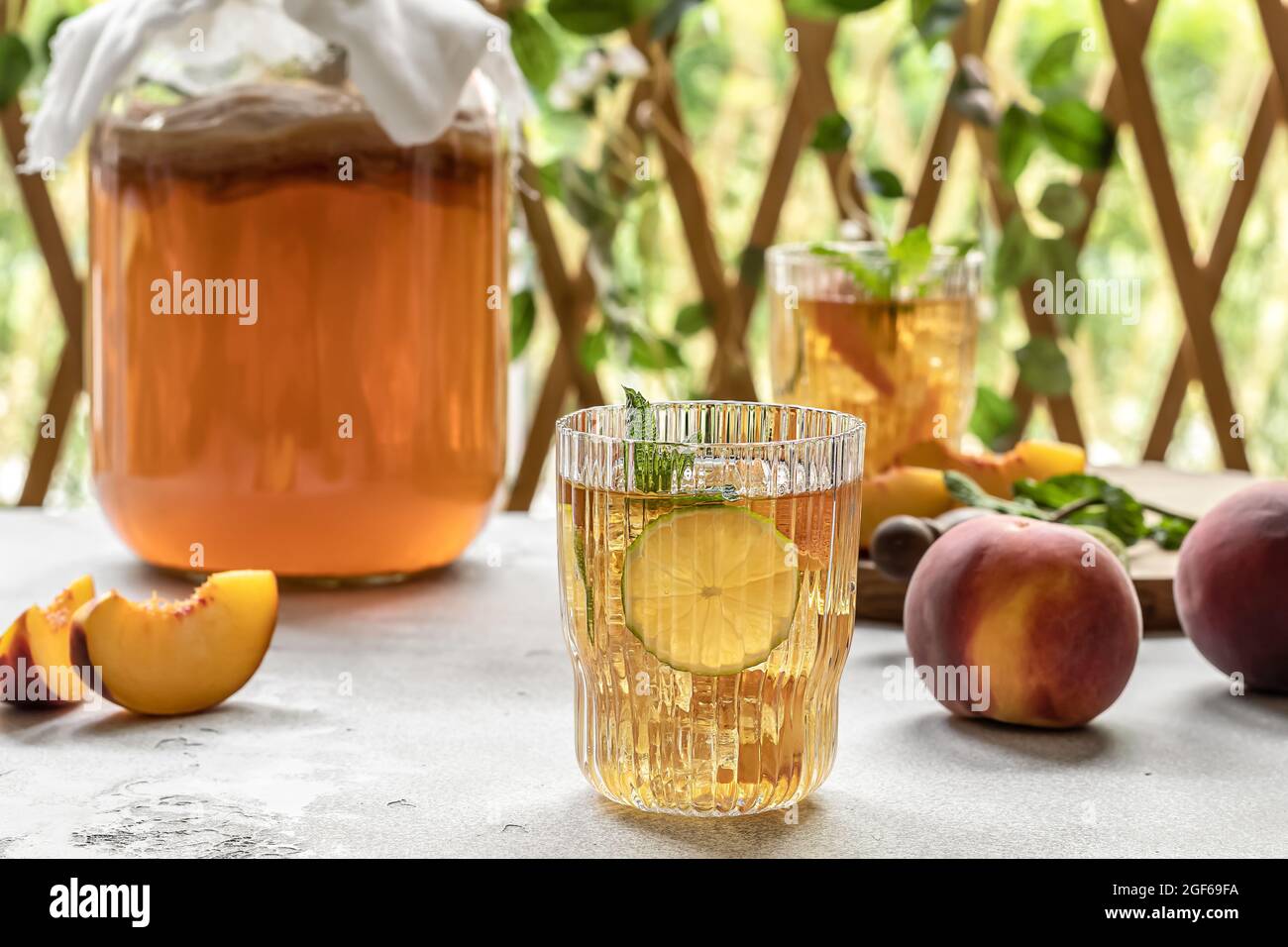 Thé Kombucha légèrement alcoolique, boisson légèrement effervescente avec pêche et citron vert. Fermentation maison. Probiotique, boisson saine pour l'intestin. Banque D'Images