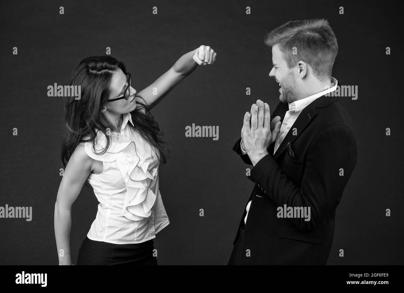 Confrontation par la force. Une femme en colère lance un coup de poing sur un collègue. Conflit sur le lieu de travail. Relations difficiles. Lutte pour le pouvoir et la faveur. Relations Banque D'Images