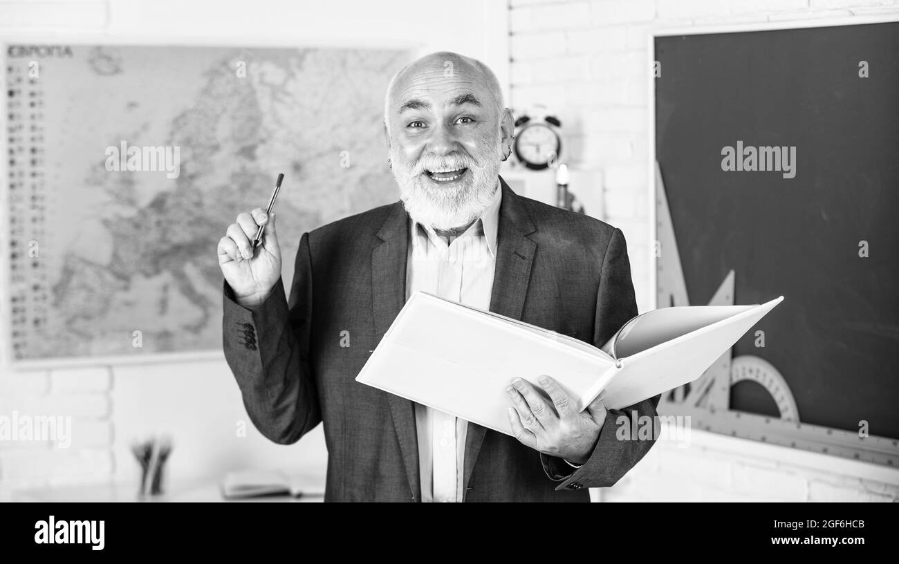 Créez un environnement d'étude libre de distraction. L'éducation mathématique à l'école. L'homme barbu donne des notes. Écrivez des notes dans le livre. Le conférencier senior heureux prend des notes Banque D'Images