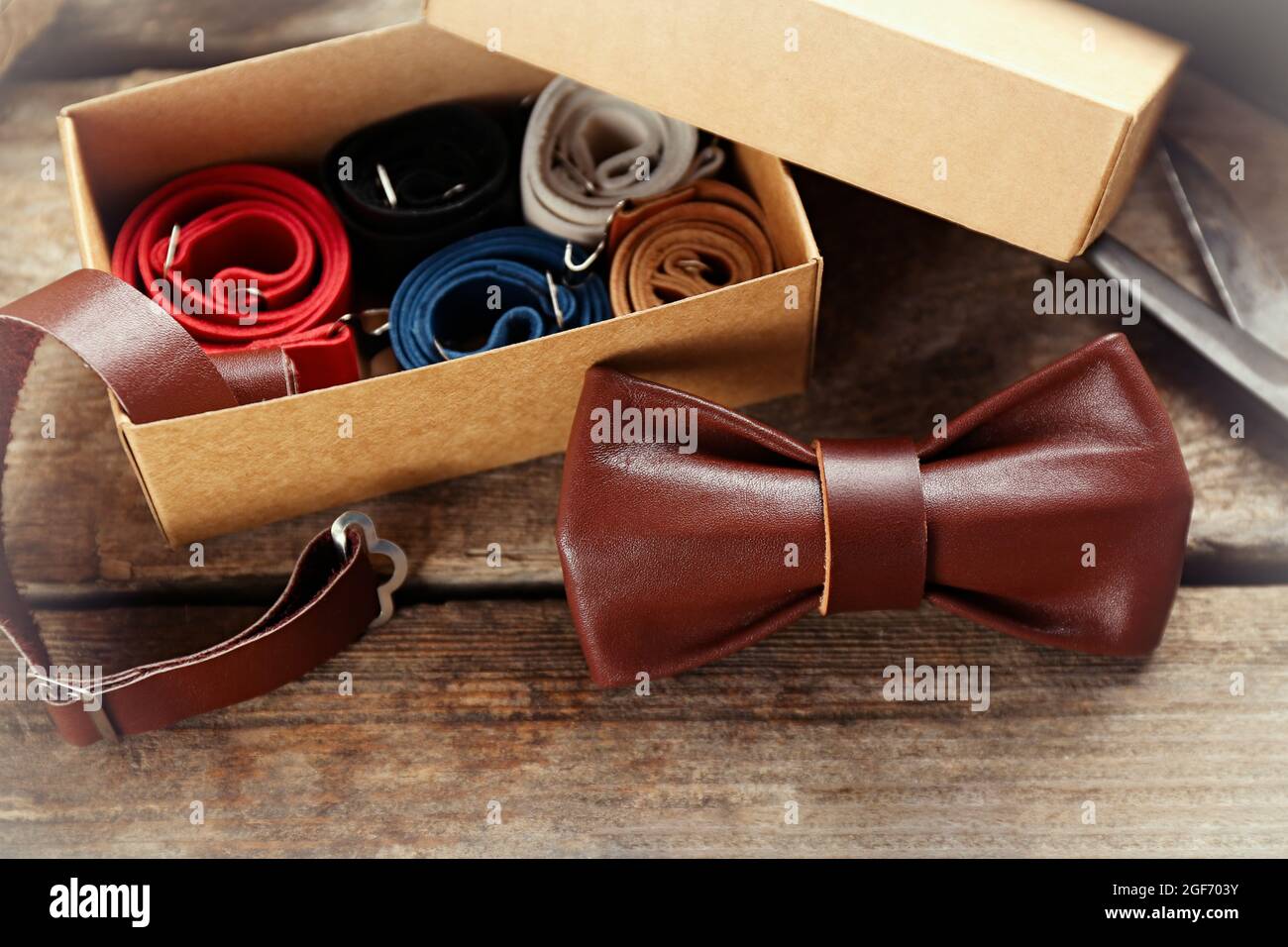 Noeud papillon en cuir marron et boîte cadeau en carton pleine de cravates  sur table en bois, gros plan Photo Stock - Alamy