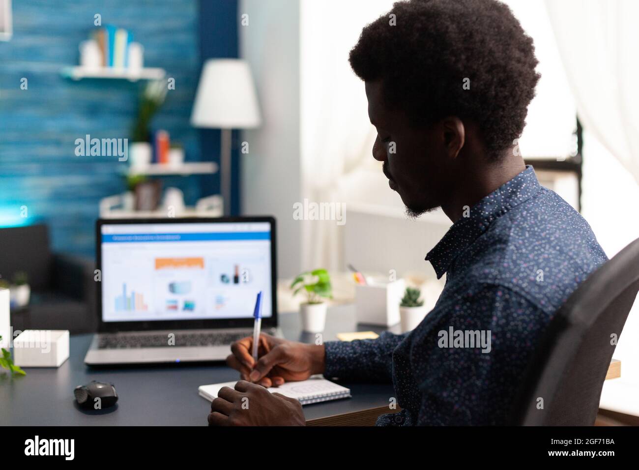 Homme noir travaillant à domicile à l'aide de l'application de données d'économie financière sur ordinateur portable. Afro-américain Guy utilisateur d'ordinateur en utilisant les affaires lieu de travail Internet en ligne site de communication de l'emploi style de vie Banque D'Images