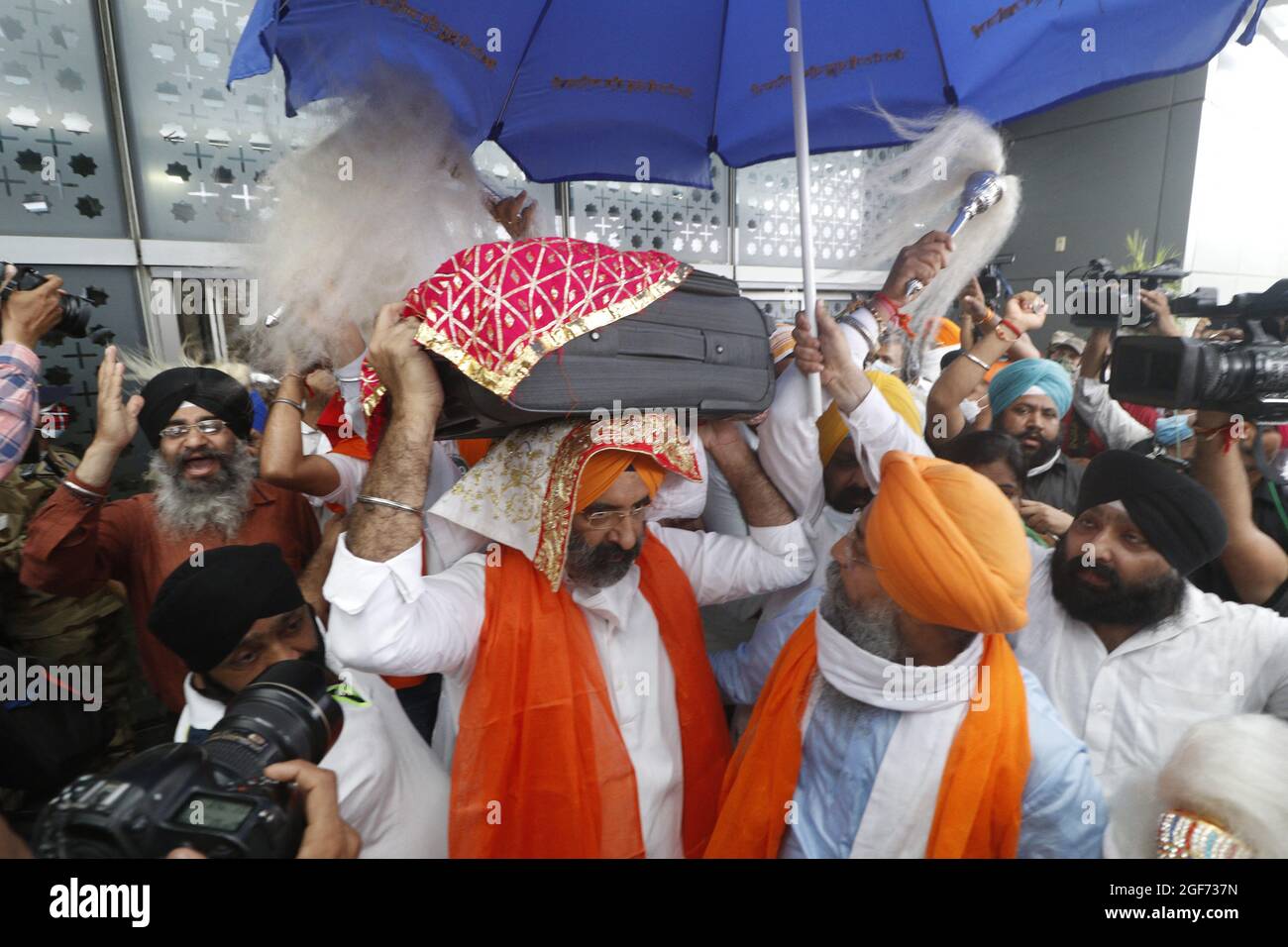 Les membres de Sikh riligion portent 3 Saroops de Sri Guru Granth Sahib, l'écriture sacrée à T3, aéroport IGI à New Delhi, Inde, le 24 août 2021. Photo par Anshuman Akash/ABACAPRESS.COM crédit: Abaca Press/Alay Live News Banque D'Images