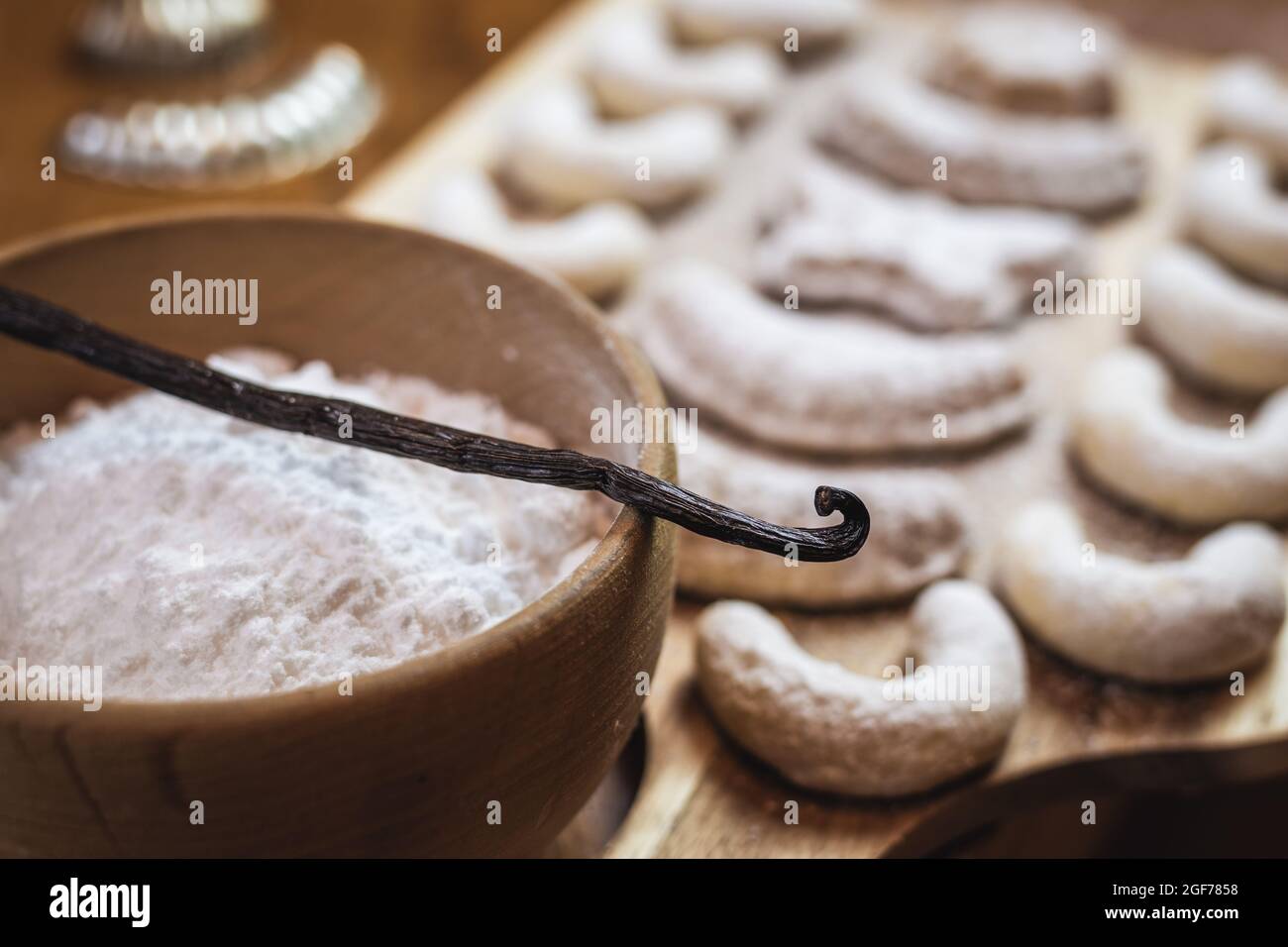 Gousse de vanille ou haricot sur bol avec sucre en poudre. Petits gâteaux de noël flous cuits sur une table en bois Banque D'Images