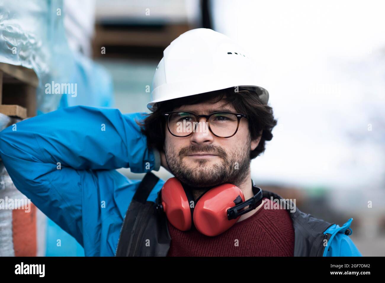 Jeune ingénieur équipé d'un casque et d'une protection auditive sur un site de travail à l'extérieur, Fribourg, Bade-Wurtemberg, Allemagne Banque D'Images