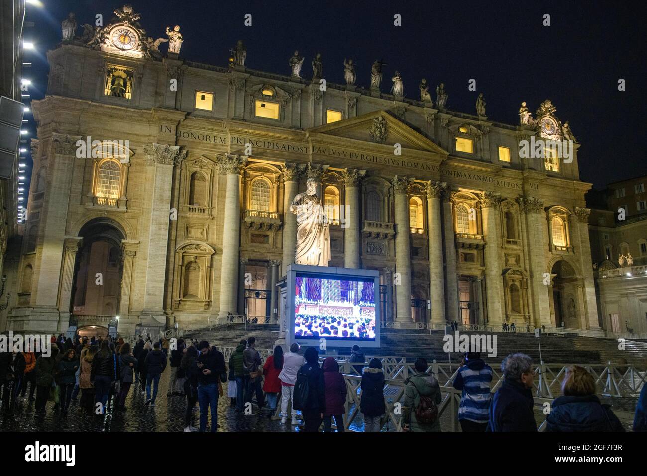 Les fidèles chrétiens à l'extérieur de la basilique Saint-Pierre regardent la messe des Papes sur grand écran la nuit, Vatican, Italie Banque D'Images