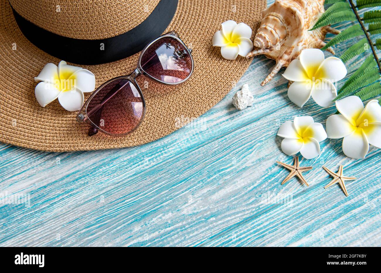 Concept de vacances d'été. Chapeau de paille et accessoires de plage avec  coquillages et étoiles de mer sur fond bleu en bois Photo Stock - Alamy