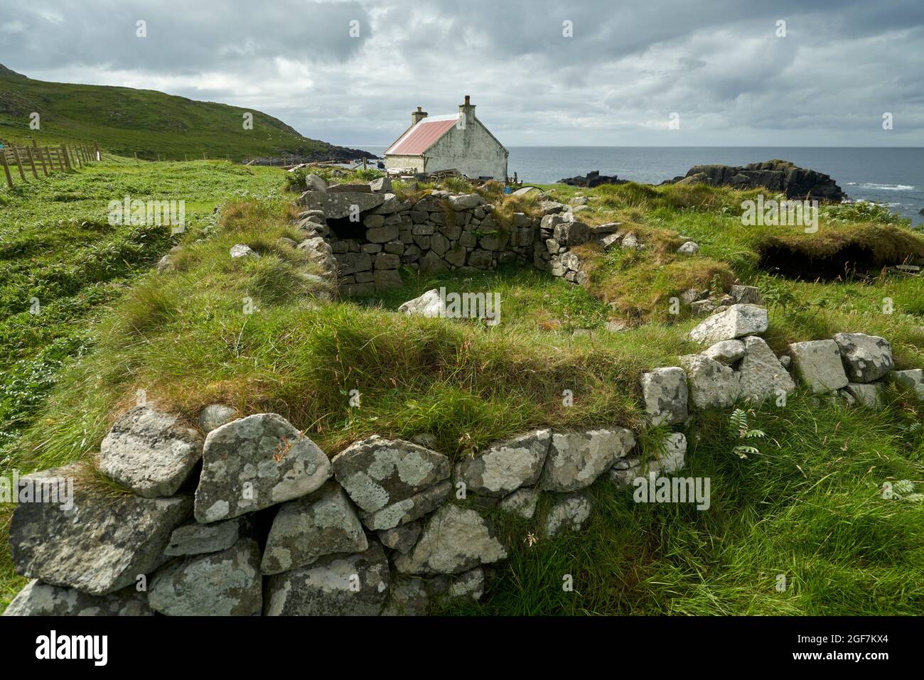 La maison ou bothy sur Eilean an Taighe dans les îles Shiant avec les ruines d'une ancienne demeure en premier plan. Banque D'Images
