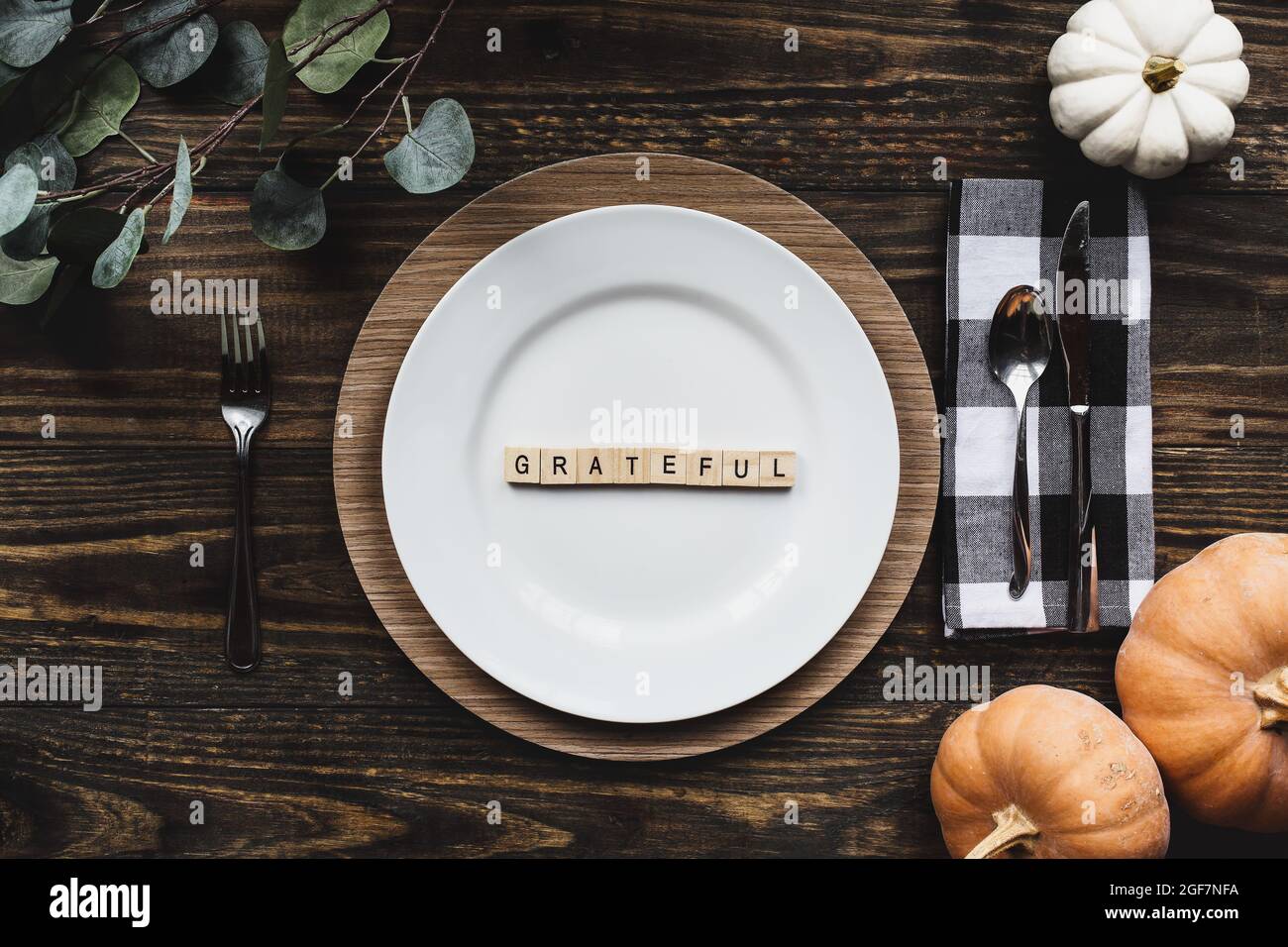 Thanksgiving placez le décor avec une assiette, serviette, sur une table décorée de plan de la position plate ou vue de dessus. Reconnaissant orthographié avec le bois de bloc laisser Banque D'Images