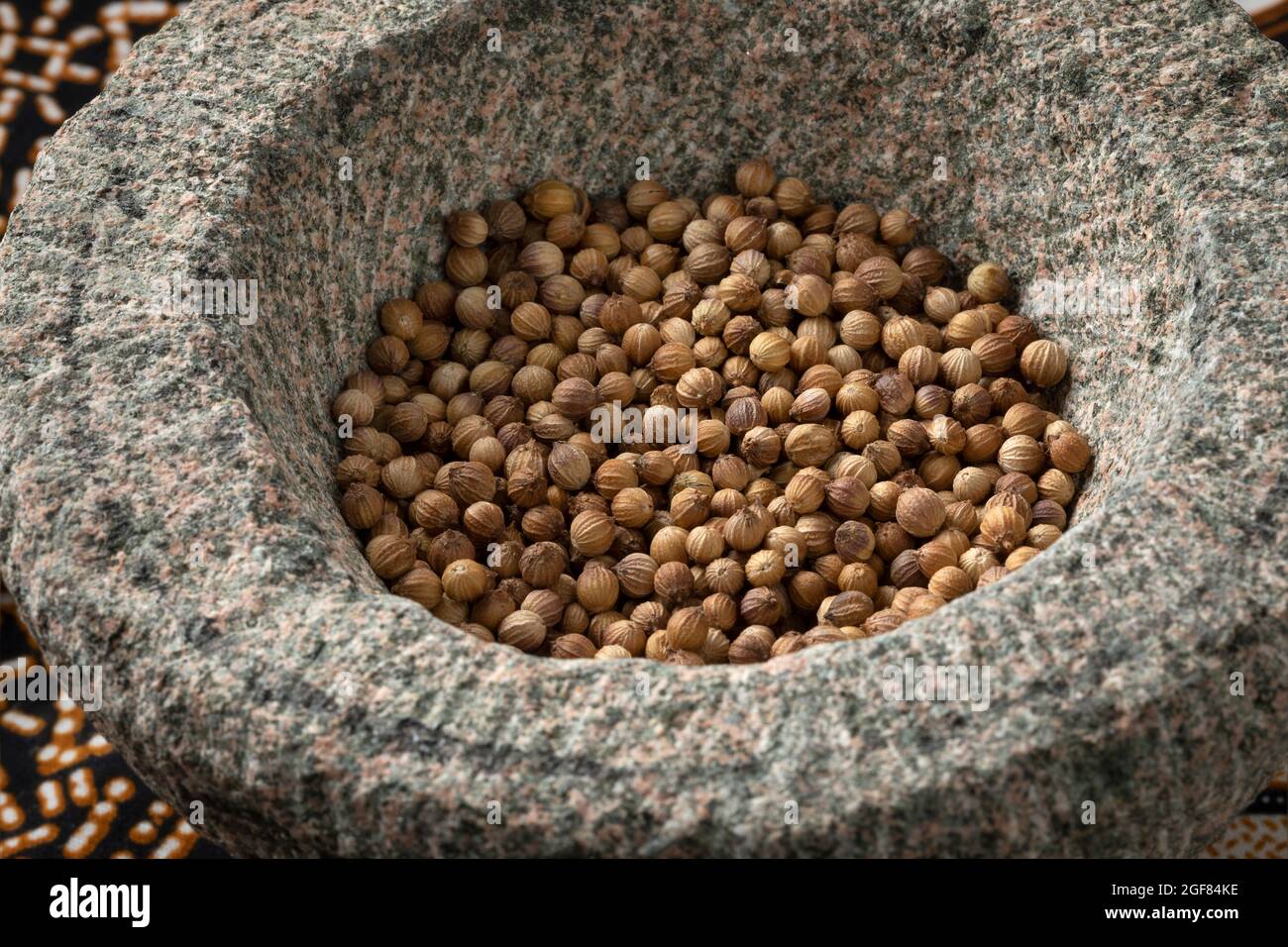 Gros plan sur les graines de coriandre séchées dans un mortier asiatique Banque D'Images