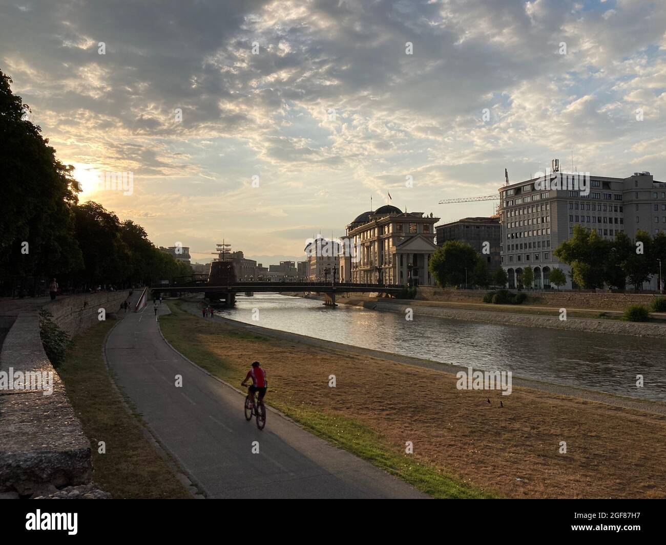 homme en vélo dans le remblai pendant le coucher du soleil Banque D'Images