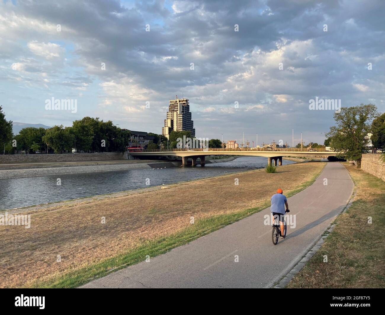 homme à vélo sur le remblai de la rivière pendant le coucher du soleil Banque D'Images