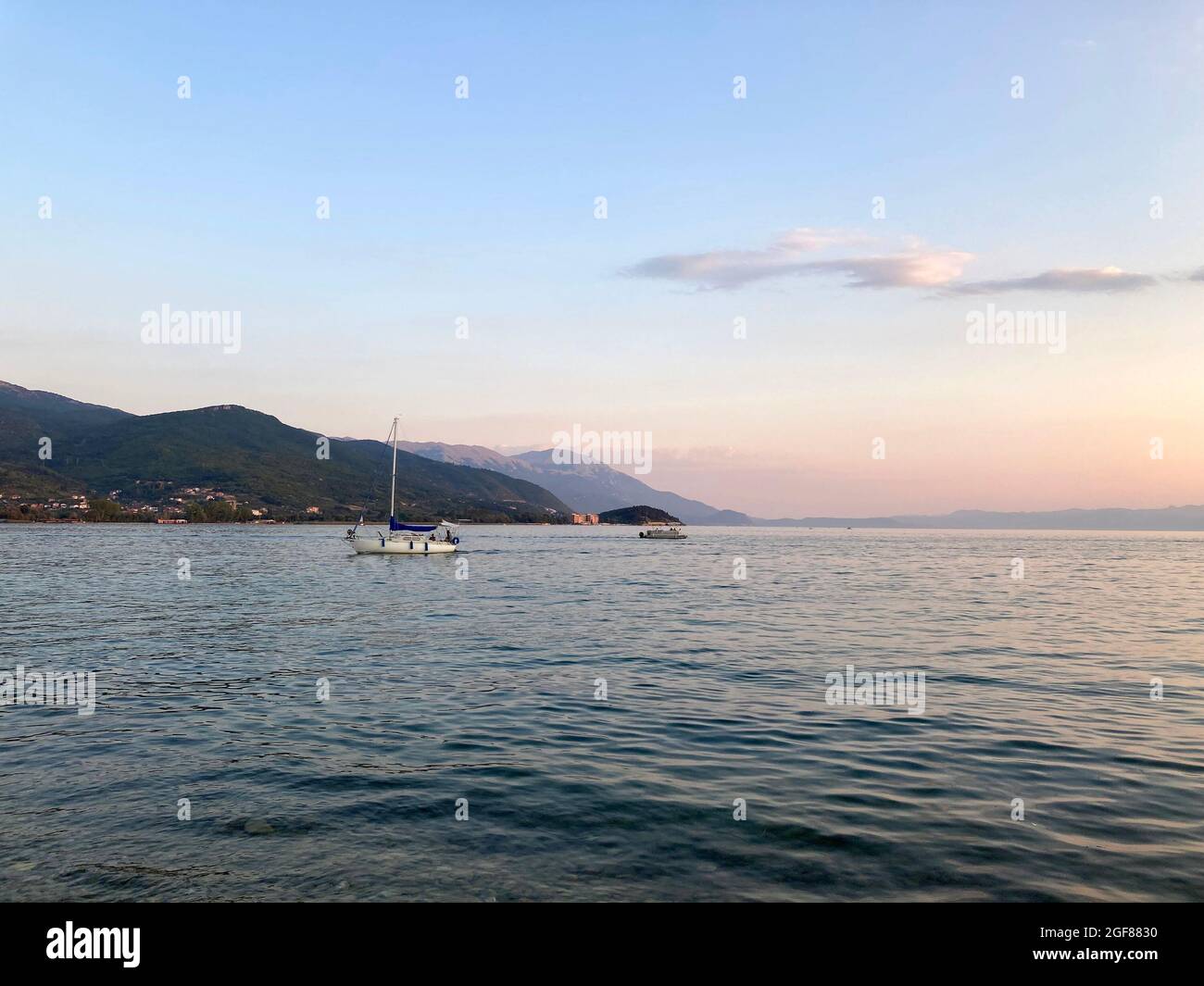 Coucher de soleil sur le lac Ohrid. Vue sur la montagne et le yacht Banque D'Images