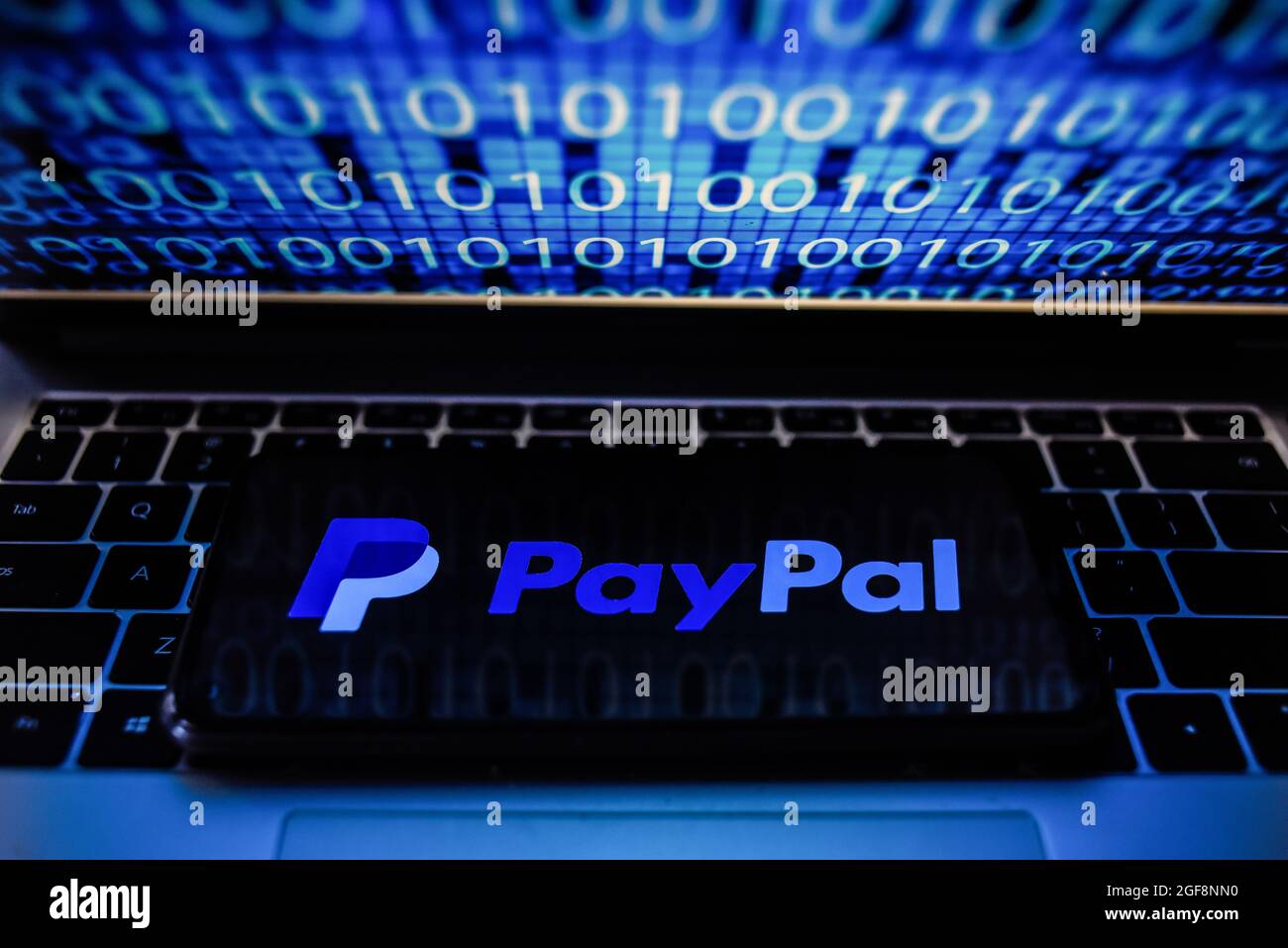 Portugal. 24 août 2021. Sur cette photo, un logo PayPal apparaît sur un smartphone avec un code binaire sur l'écran d'un ordinateur portable. Crédit : SOPA Images Limited/Alamy Live News Banque D'Images