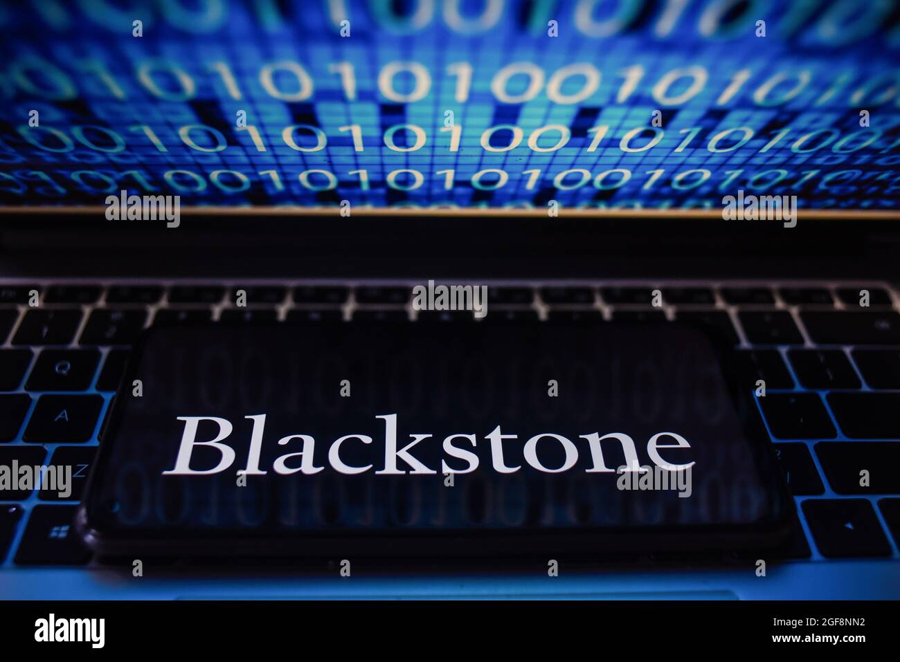 Portugal. 24 août 2021. Sur cette photo, un logo Blackstone apparaît sur un smartphone avec un code binaire sur l'écran d'un ordinateur portable. Crédit : SOPA Images Limited/Alamy Live News Banque D'Images