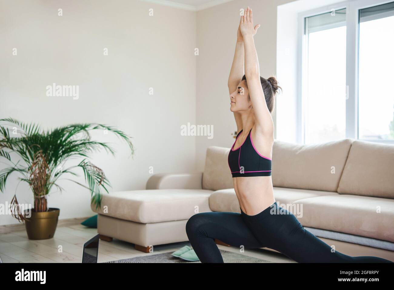 Femme qui s'étire avec un ordinateur portable sur le sol pour un style de vie. Posture du corps de yoga. Sport, mode de vie sain. Banque D'Images