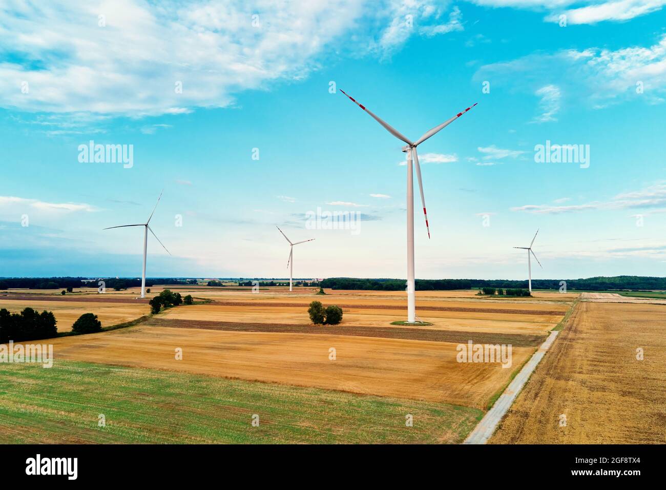 Moulin parmi les champs agricoles. Générateur d'éolienne à la journée d'été. Concept de l'énergie éolienne, énergie renouvelable et suistanable pour la protection du climat Banque D'Images