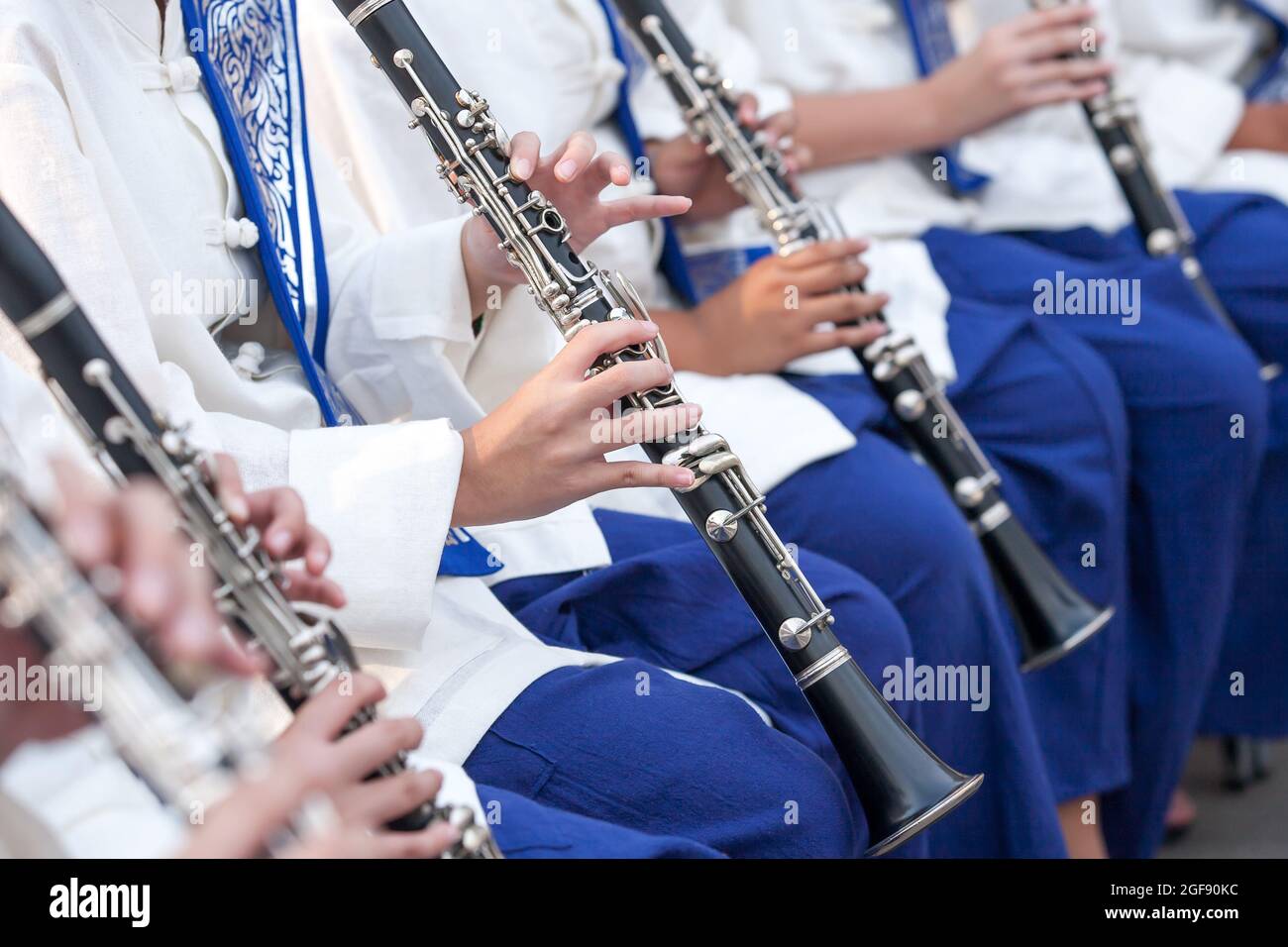Un orchestre de jeunes thaïlandais en vêtements traditionnels du nord de la Thaïlande se produit dans un festival de musique traditionnelle. Gros plan de jeunes musiciens jouant à la main clarinette. Banque D'Images