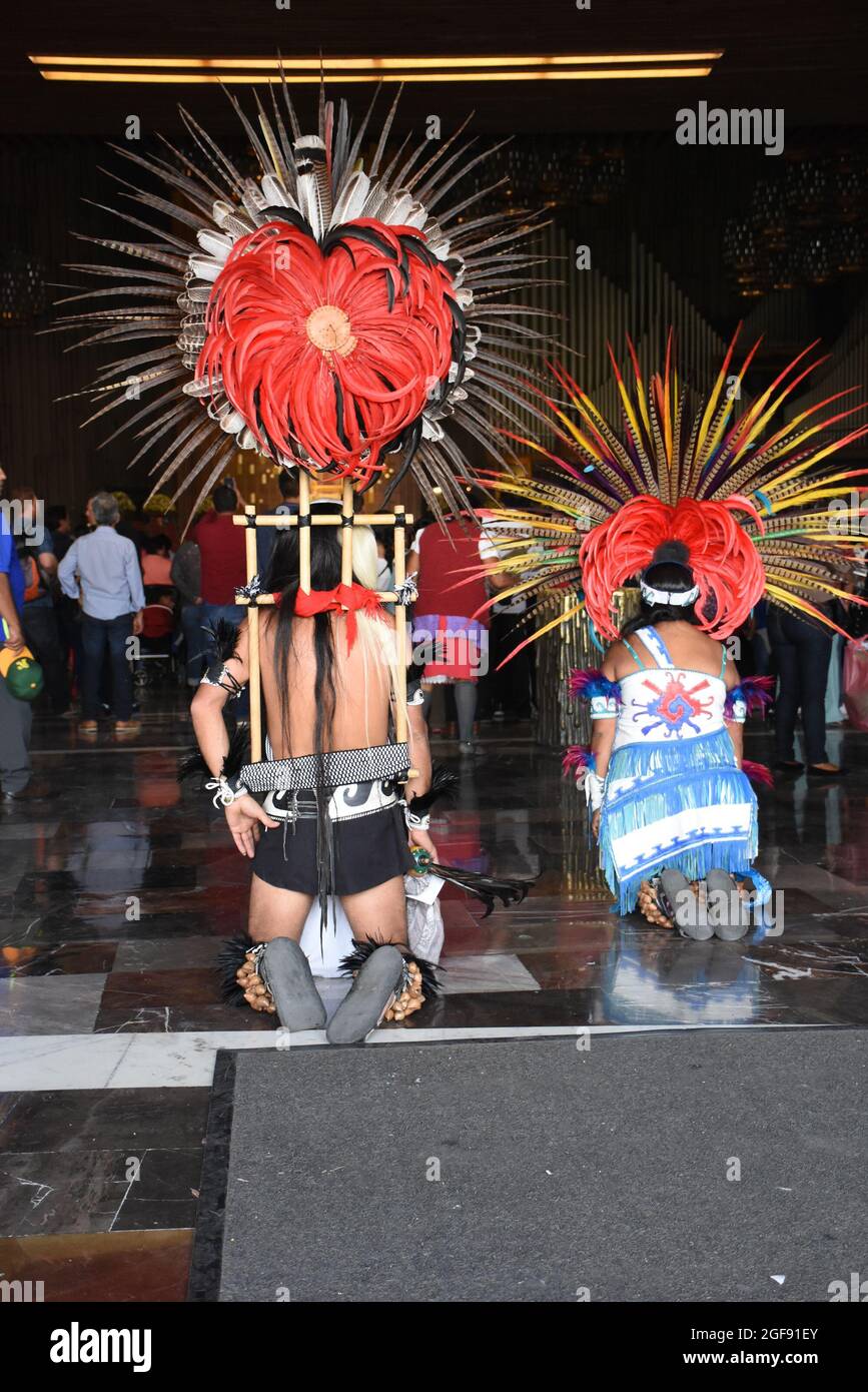 Deux danseurs indigènes s'agenouillent à l'entrée de la cathédrale de la Villa de Guadalupe. Banque D'Images