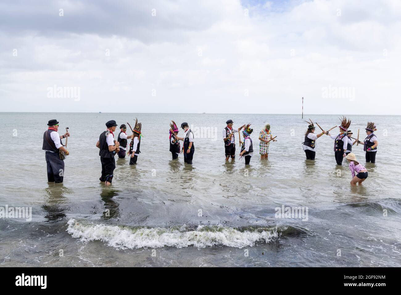 Dead Horse Morris, groupe de danseurs morris, prend une paddle dans Viking Bay après avoir donné un spectacle à la Broadsescaliers Folk week, le 2021 août Banque D'Images